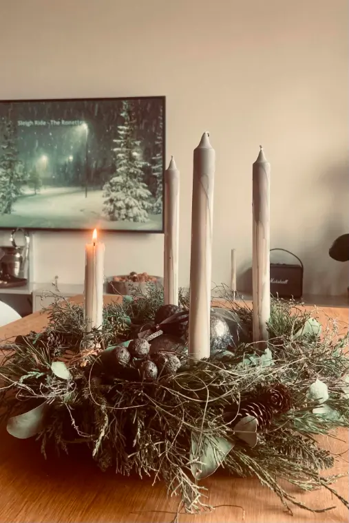 Adventní věnec s vysokými svícemi na stole